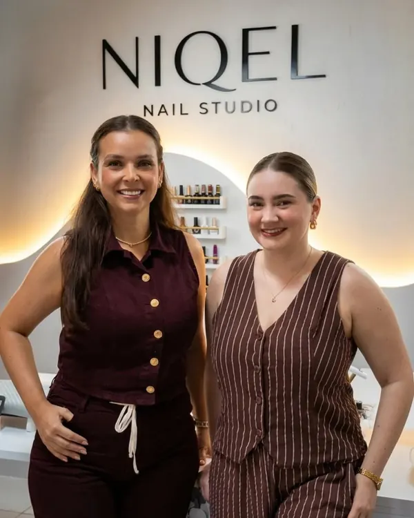 Equipe do Niqel Nail Studio em frente ao letreiro do studio