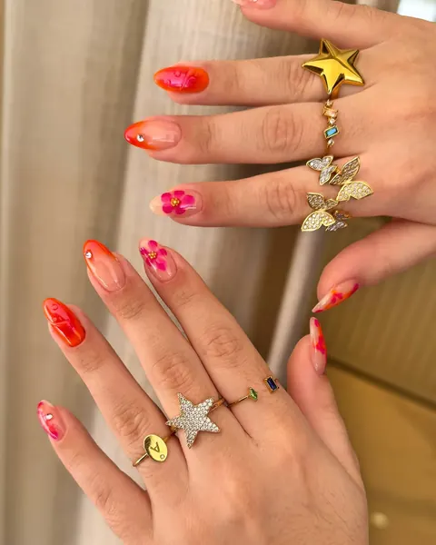 Unhas com flores em laranja e rosa