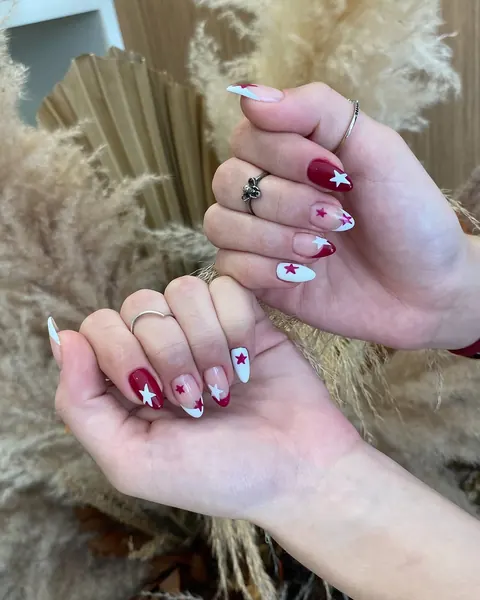 Nail art em vinho com detalhes brancos